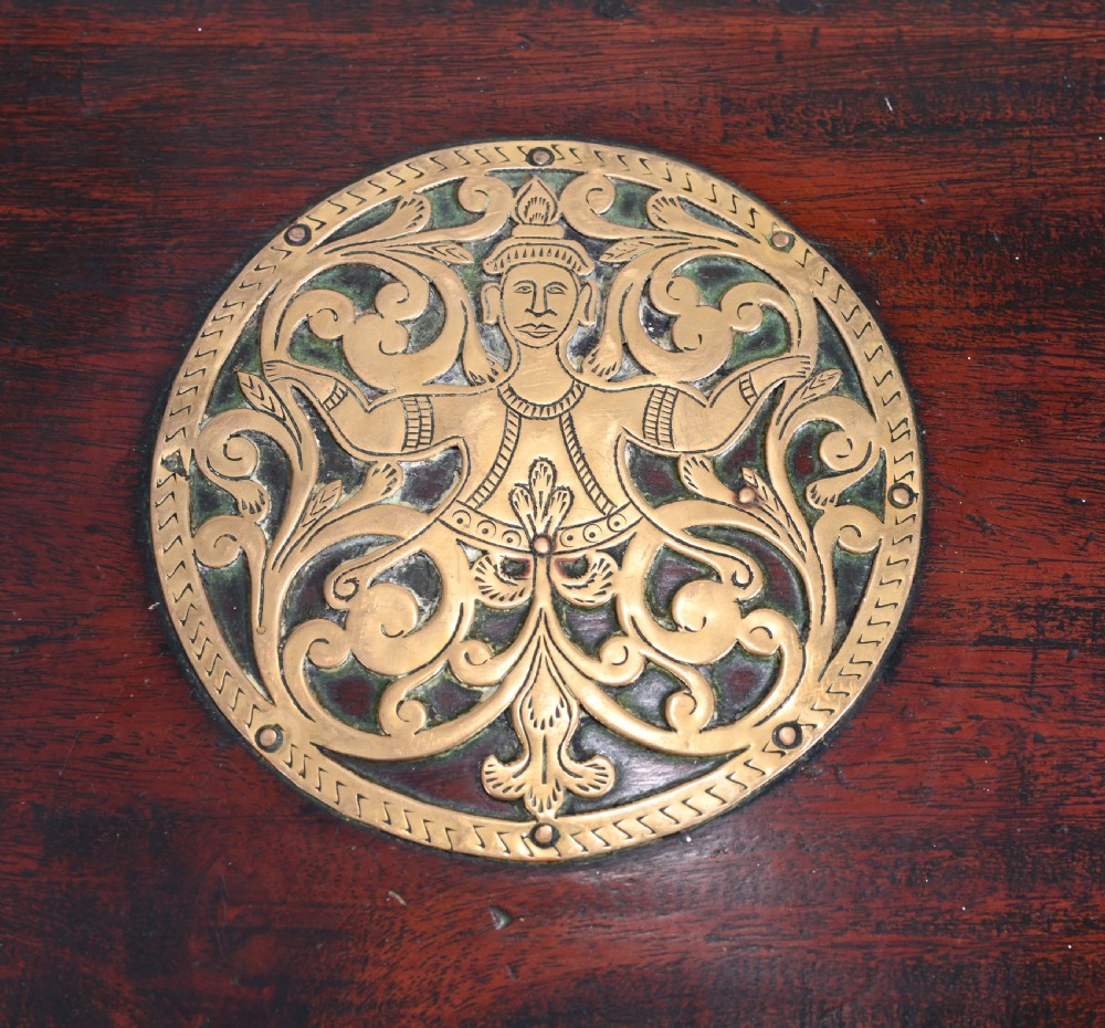 An antique dark wood Indian dowry casket decorated with intricate pierced brass straps and studs, supported on a turned central pedestal base. View IV