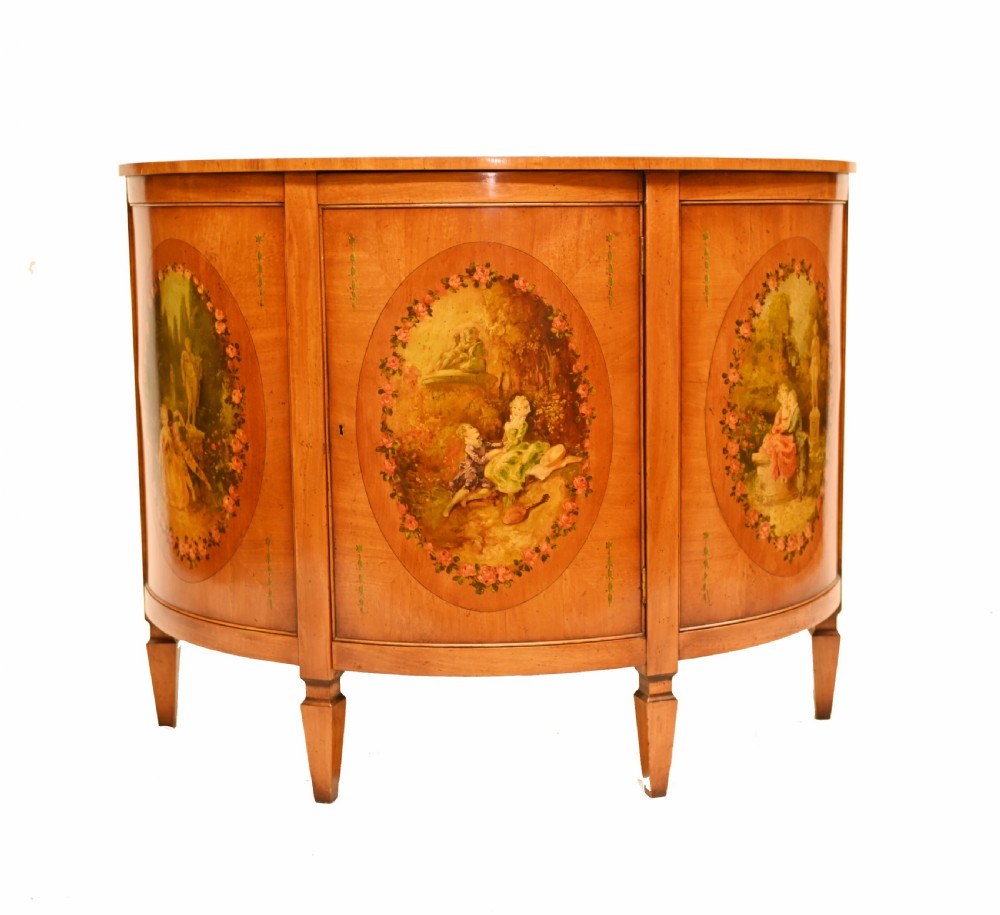 A semi-circular satinwood commode cabinet featuring three oval painted vignettes with classical figurative scenes and floral borders. View II