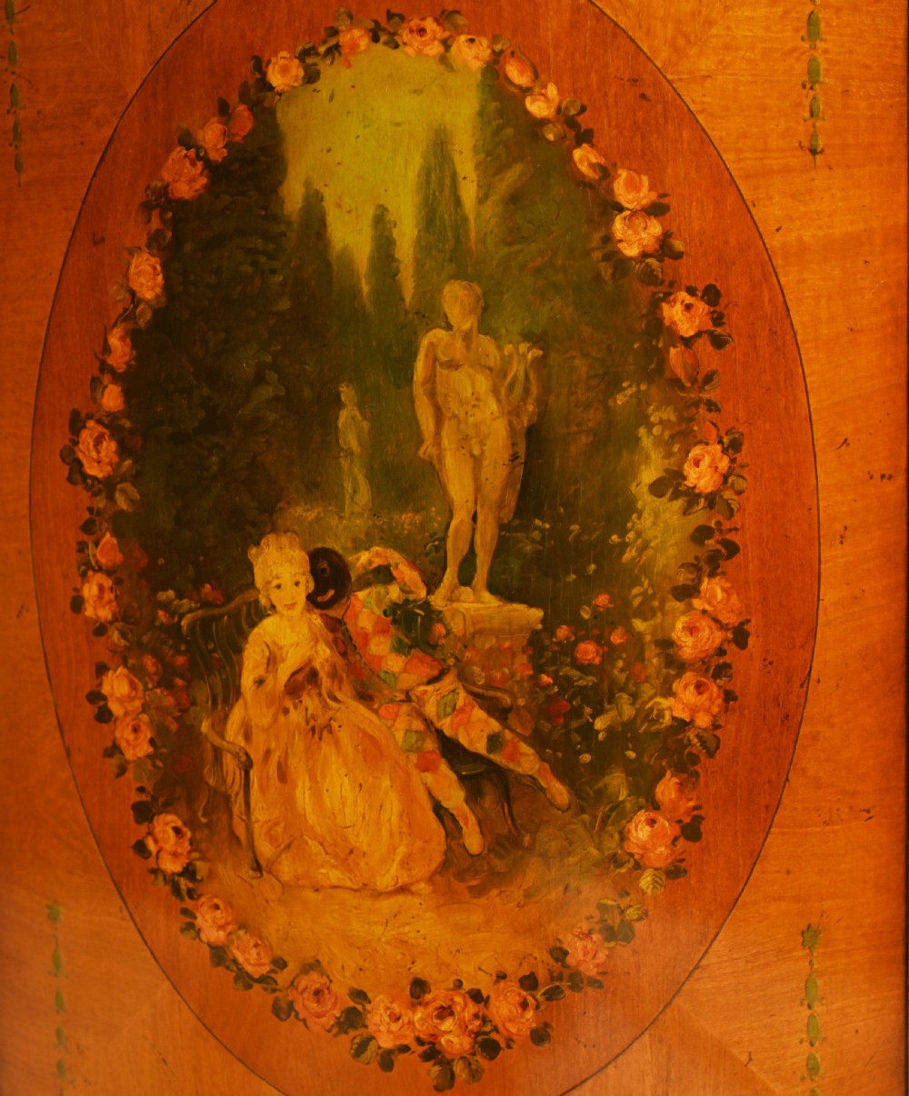 A semi-circular satinwood commode cabinet featuring three oval painted vignettes with classical figurative scenes and floral borders. View VI