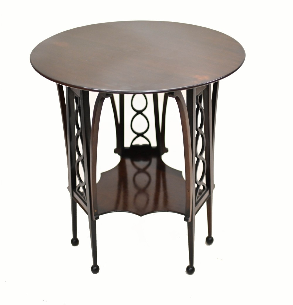 A late nineteenth-century dark mahogany occasional table featuring a circular top, pierced geometric fretwork legs, an undertier shelf, and ball feet. View II