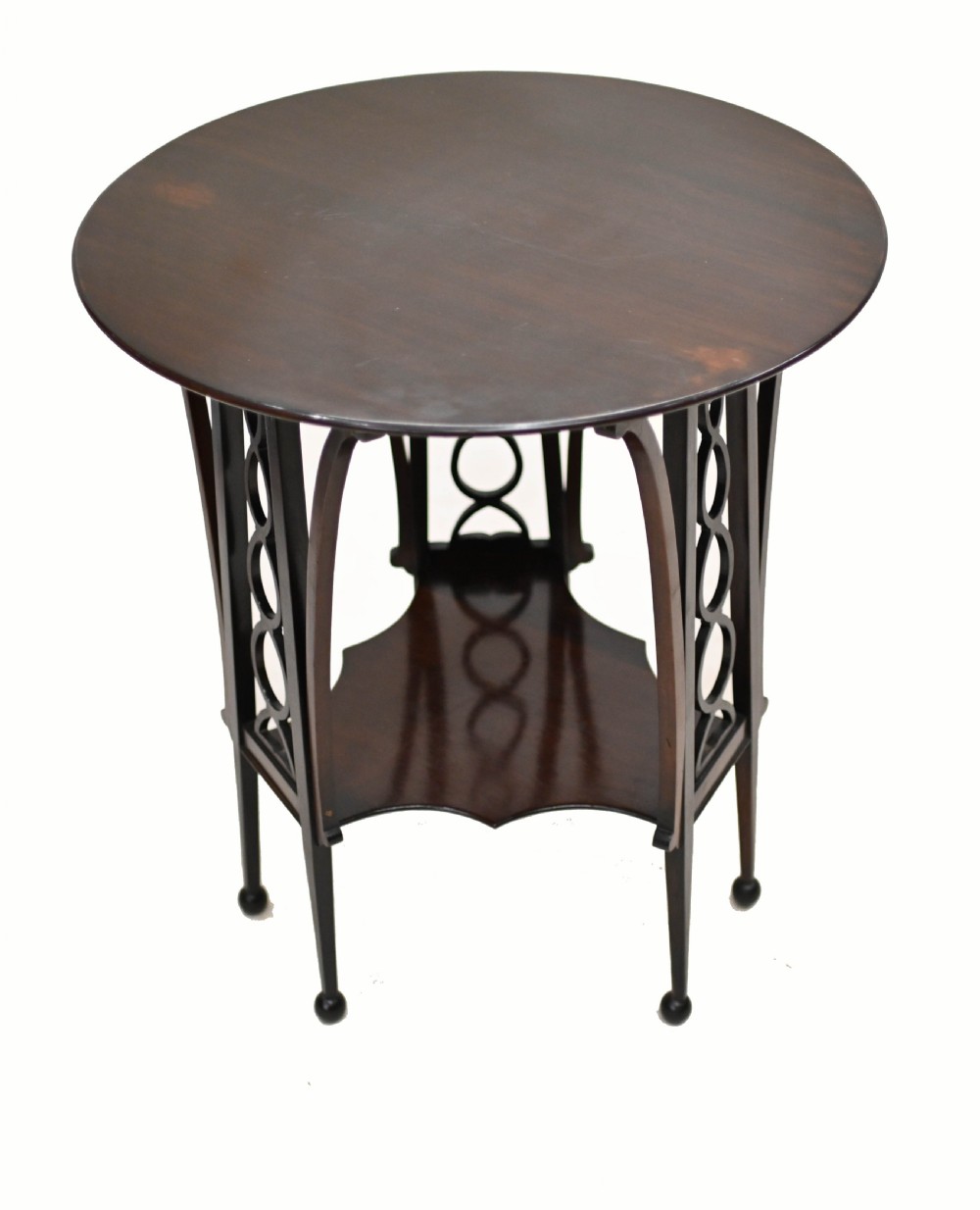 A late nineteenth-century dark mahogany occasional table featuring a circular top, pierced geometric fretwork legs, an undertier shelf, and ball feet. View IV