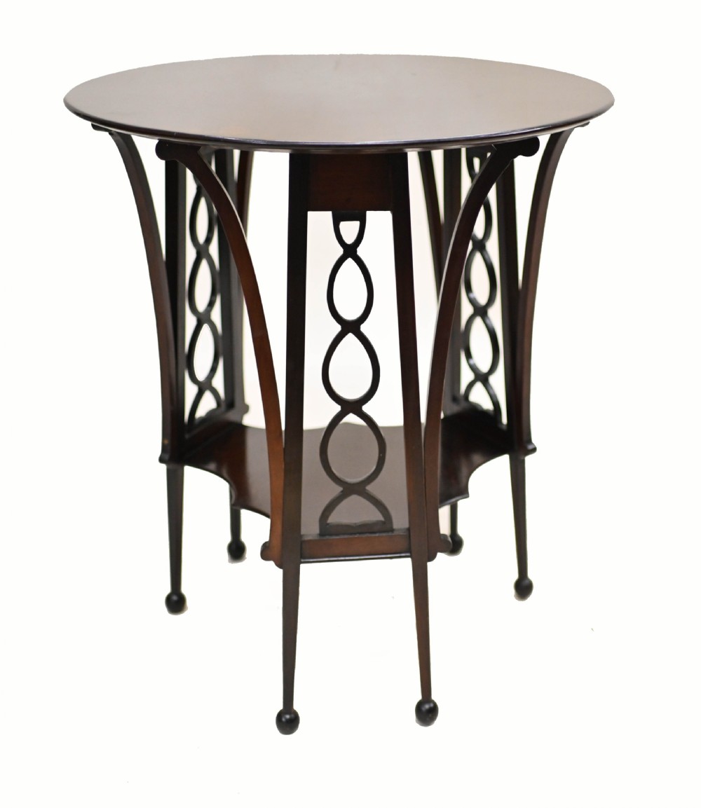 A late nineteenth-century dark mahogany occasional table featuring a circular top, pierced geometric fretwork legs, an undertier shelf, and ball feet. View VI
