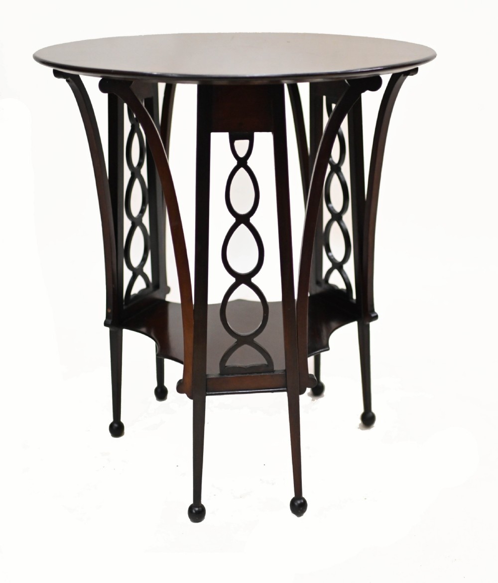 A late nineteenth-century dark mahogany occasional table featuring a circular top, pierced geometric fretwork legs, an undertier shelf, and ball feet. View VII