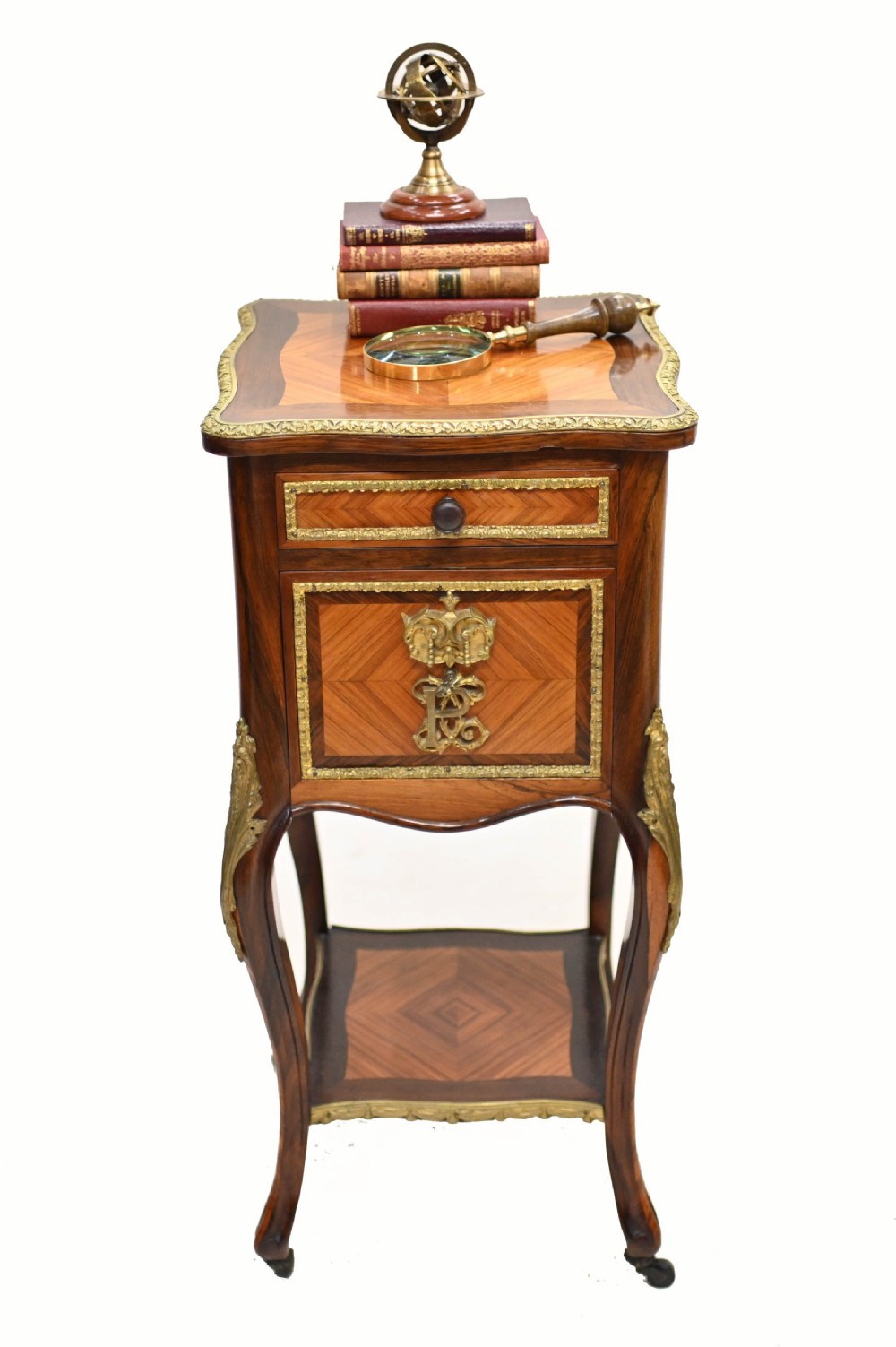 A late nineteenth-century dark mahogany occasional table featuring a circular top, pierced geometric fretwork legs, an undertier shelf, and ball feet. View IX