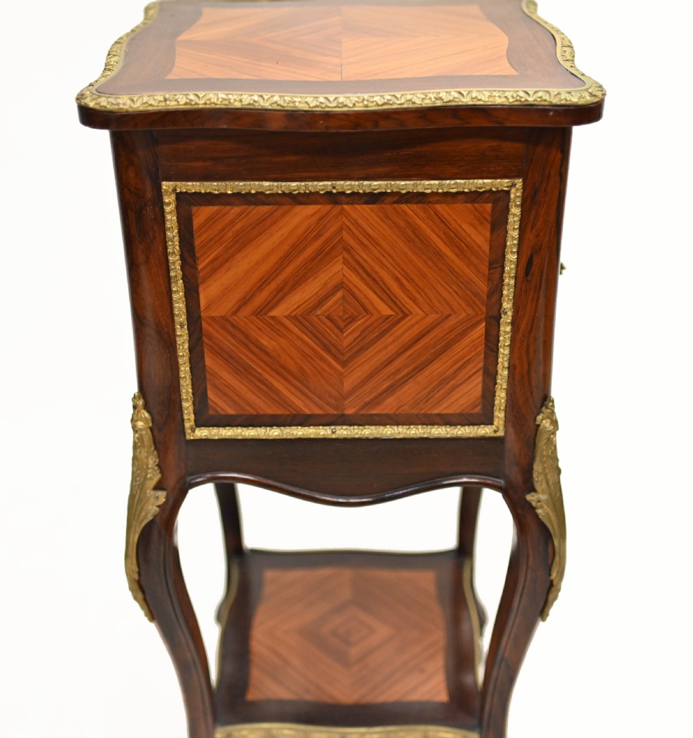 A late nineteenth-century dark mahogany occasional table featuring a circular top, pierced geometric fretwork legs, an undertier shelf, and ball feet. View XII