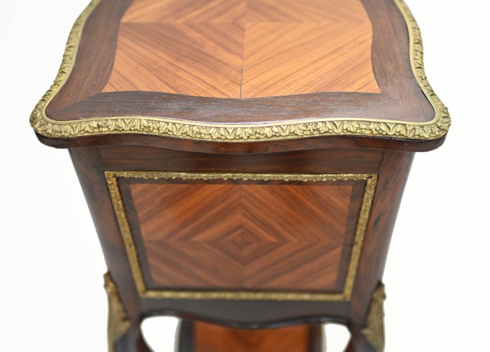 A late nineteenth-century dark mahogany occasional table featuring a circular top, pierced geometric fretwork legs, an undertier shelf, and ball feet. View XIV