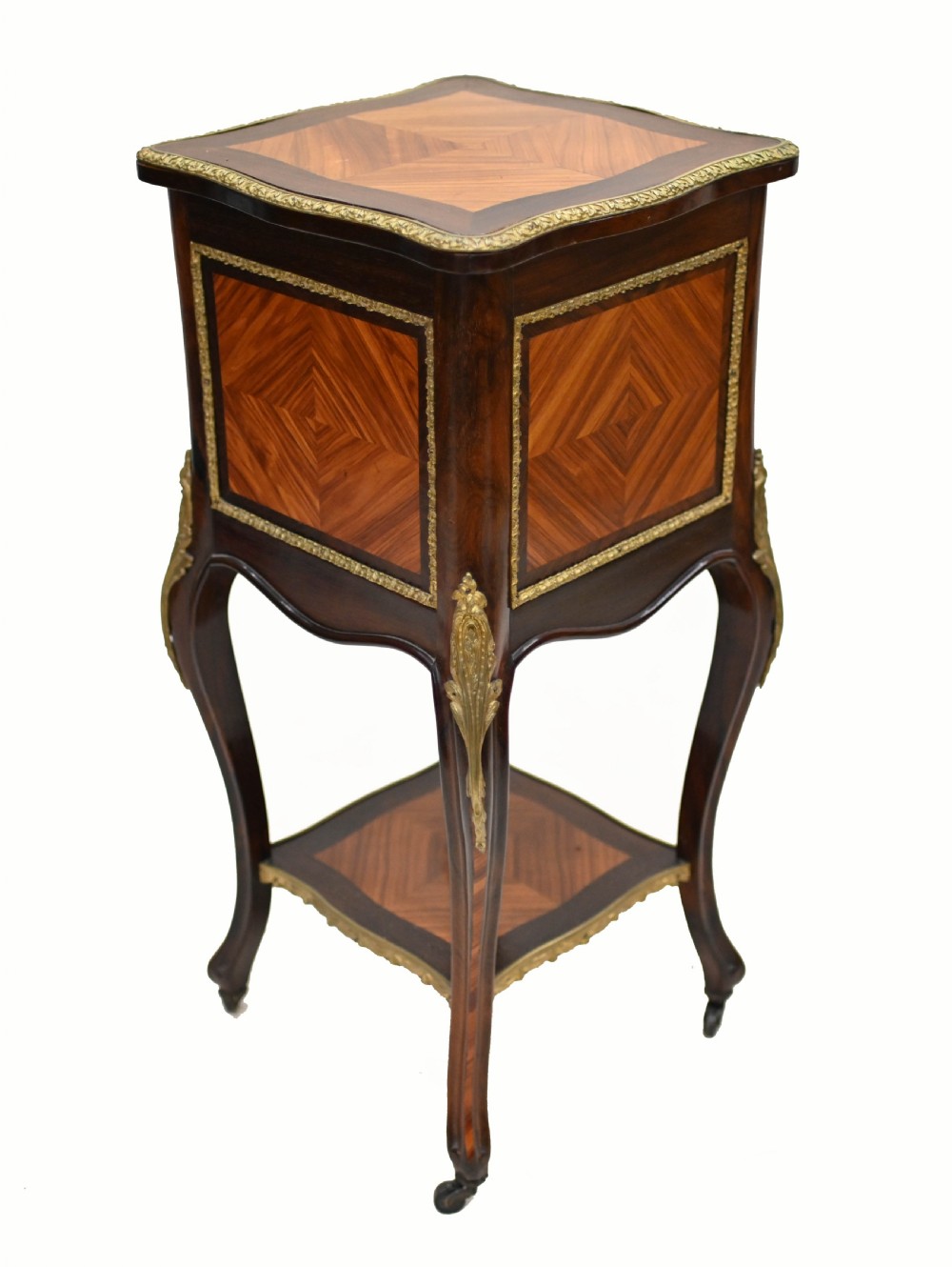 A late nineteenth-century dark mahogany occasional table featuring a circular top, pierced geometric fretwork legs, an undertier shelf, and ball feet. View XV