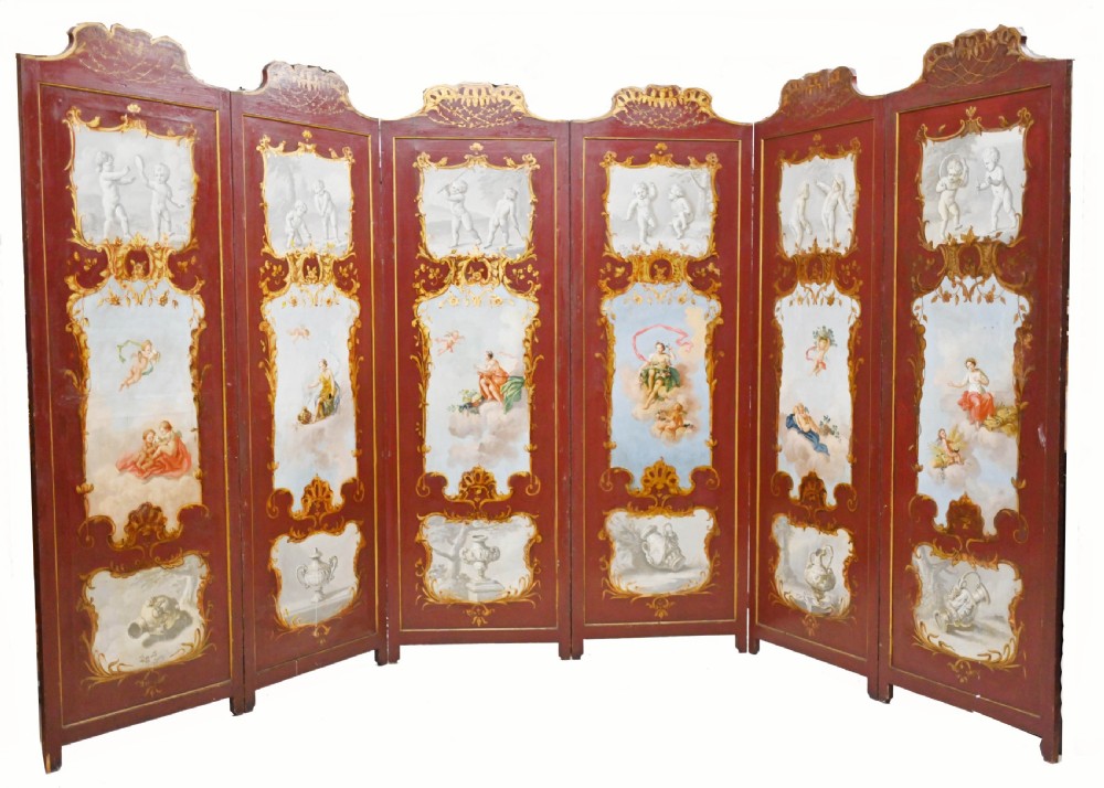 A red six-panel folding screen painted with classical figures, cherubs, and urns within gilded scrollwork borders.