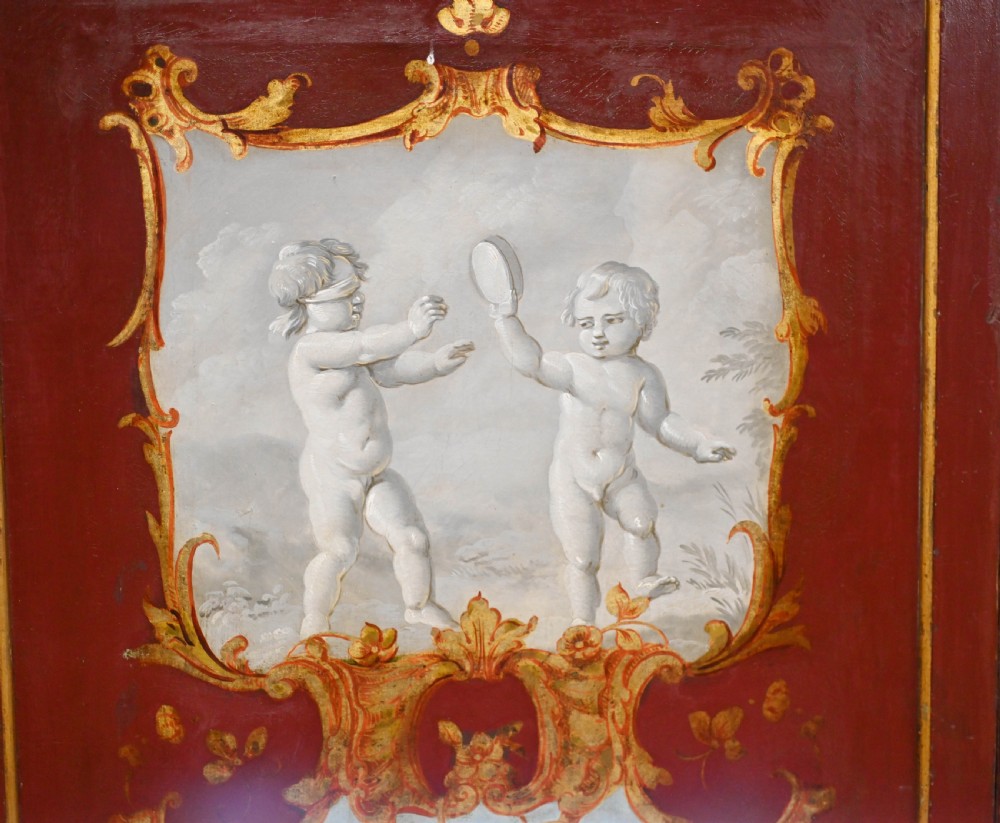A red six-panel folding screen painted with classical figures, cherubs, and urns within gilded scrollwork borders. View VI