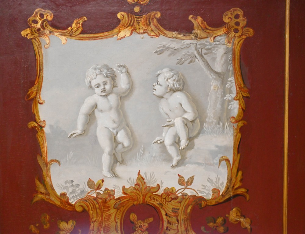 A red six-panel folding screen painted with classical figures, cherubs, and urns within gilded scrollwork borders. View VIII
