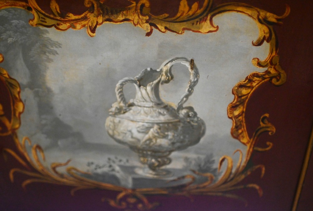 A red six-panel folding screen painted with classical figures, cherubs, and urns within gilded scrollwork borders. View XVII