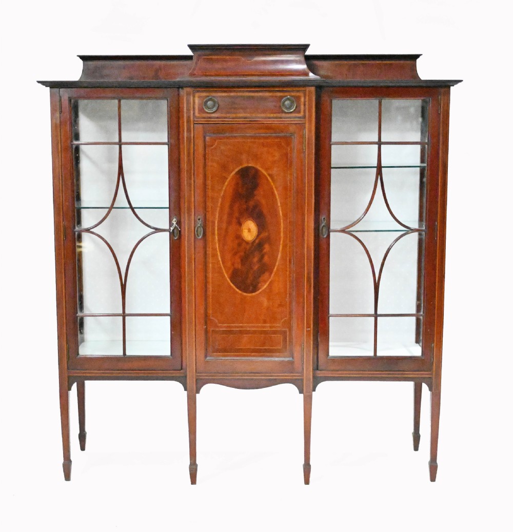 An Edwardian mahogany display cabinet featuring astragal glazed doors flanking a central inlaid cupboard door raised on square tapered legs. View II