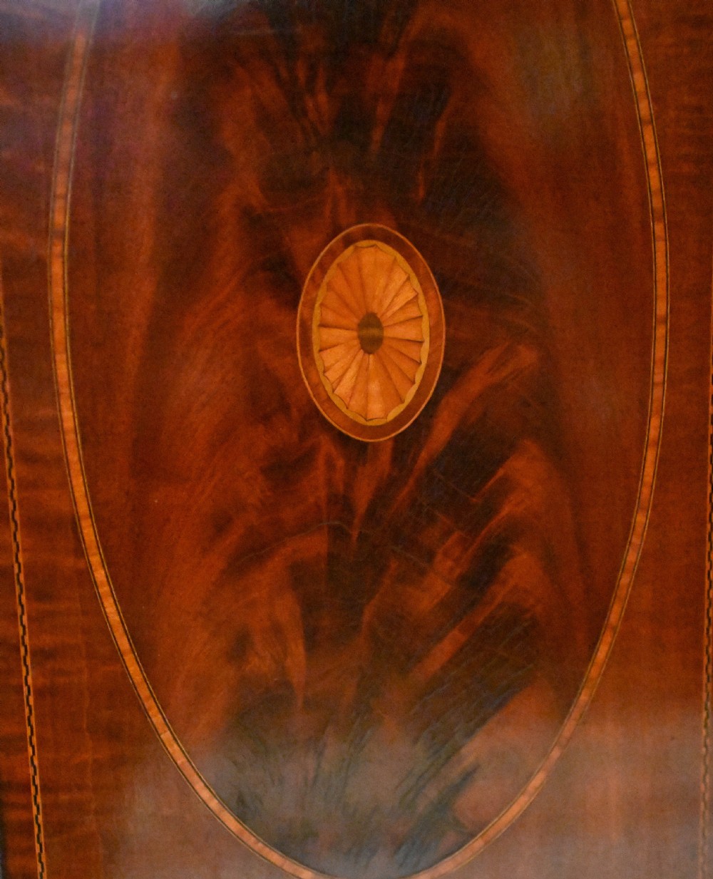 An Edwardian mahogany display cabinet featuring astragal glazed doors flanking a central inlaid cupboard door raised on square tapered legs. View III