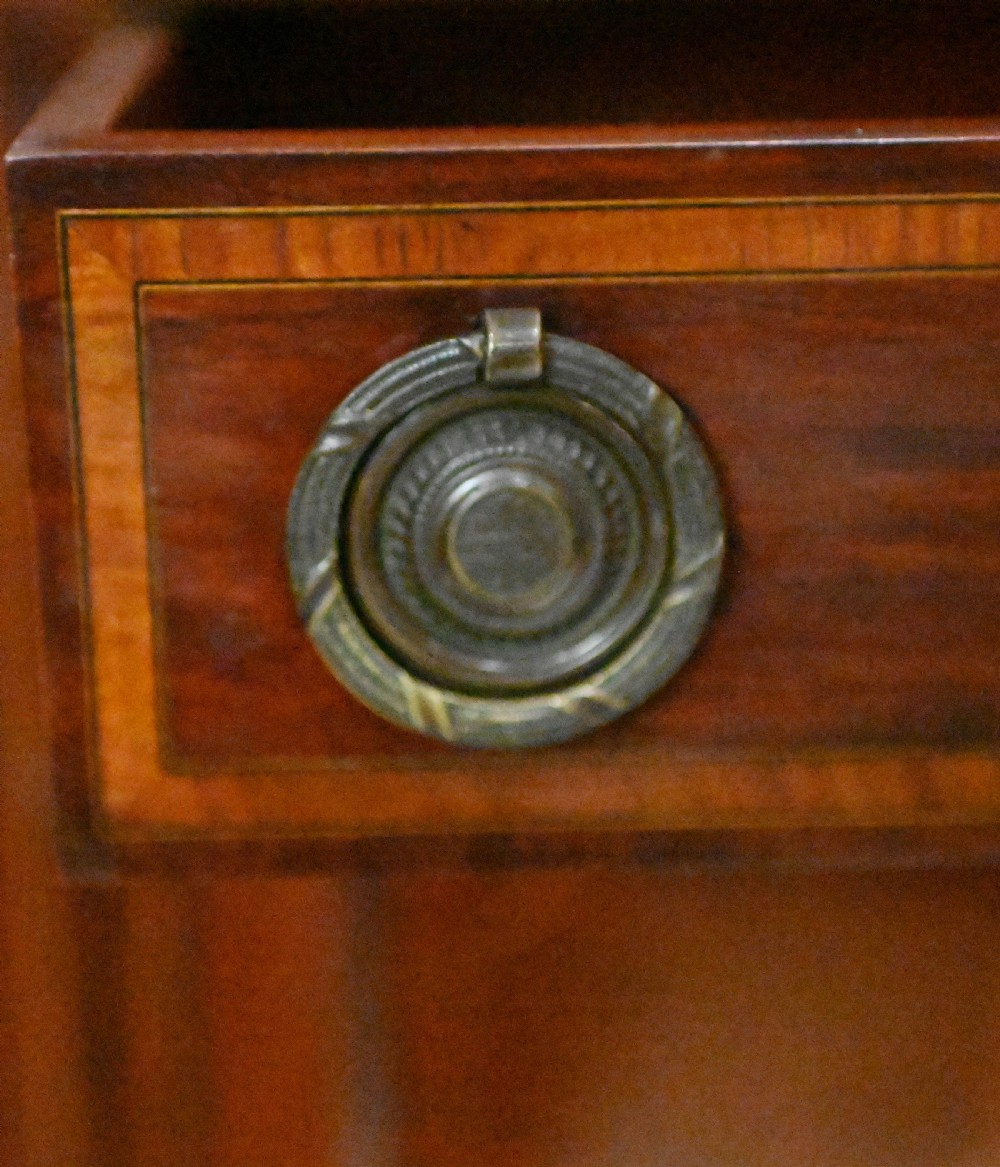 An Edwardian mahogany display cabinet featuring astragal glazed doors flanking a central inlaid cupboard door raised on square tapered legs. View VI