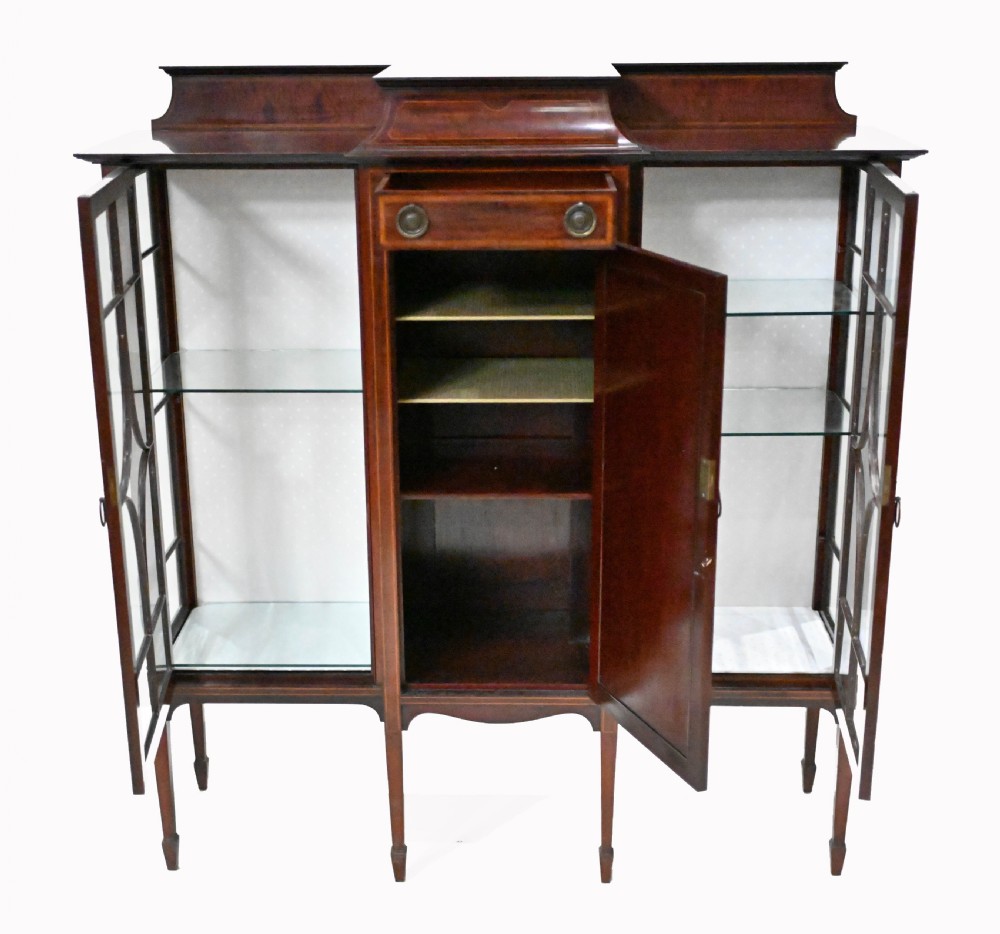 An Edwardian mahogany display cabinet featuring astragal glazed doors flanking a central inlaid cupboard door raised on square tapered legs. View VII