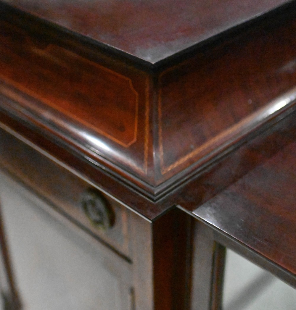 An Edwardian mahogany display cabinet featuring astragal glazed doors flanking a central inlaid cupboard door raised on square tapered legs. View X
