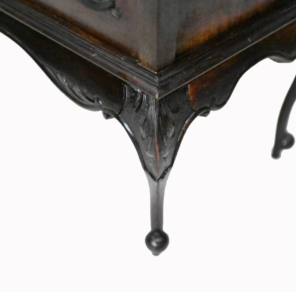 A dark mahogany Art Nouveau display cabinet featuring a pierced cresting, an asymmetrical mirrored superstructure, a single drawer, and a glazed door on slender shaped legs. View V