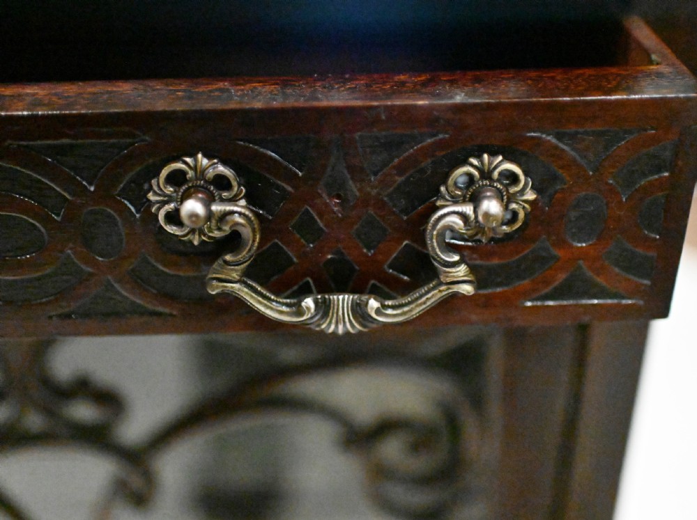 A dark mahogany Art Nouveau display cabinet featuring a pierced cresting, an asymmetrical mirrored superstructure, a single drawer, and a glazed door on slender shaped legs. View VIII