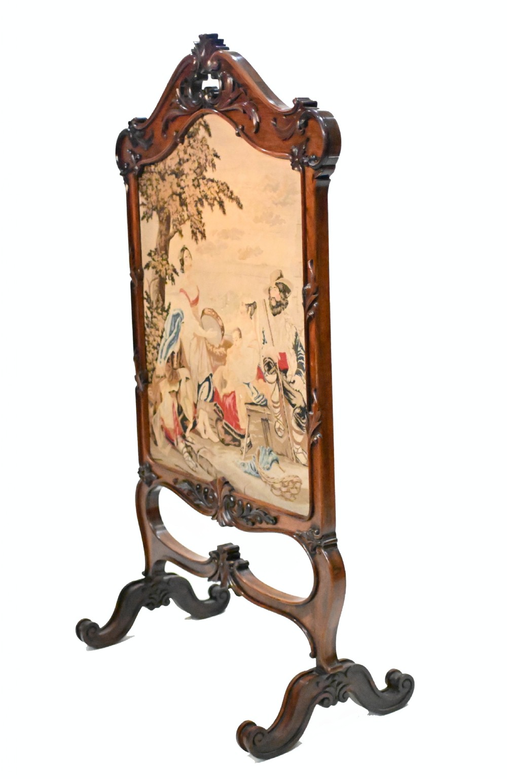 An early Victorian carved wooden fire screen featuring a hand-worked needlepoint tapestry of a pastoral scene set within a scrolled frame. View IX