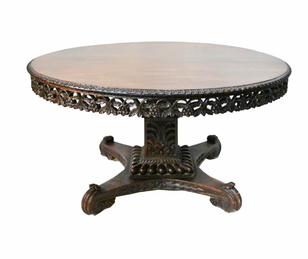 An 1840s Anglo-Indian tilt-top centre table featuring a circular padauk wood top set upon a carved pedestal base. View II