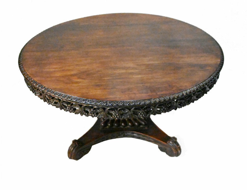 An 1840s Anglo-Indian tilt-top centre table featuring a circular padauk wood top set upon a carved pedestal base. View IV