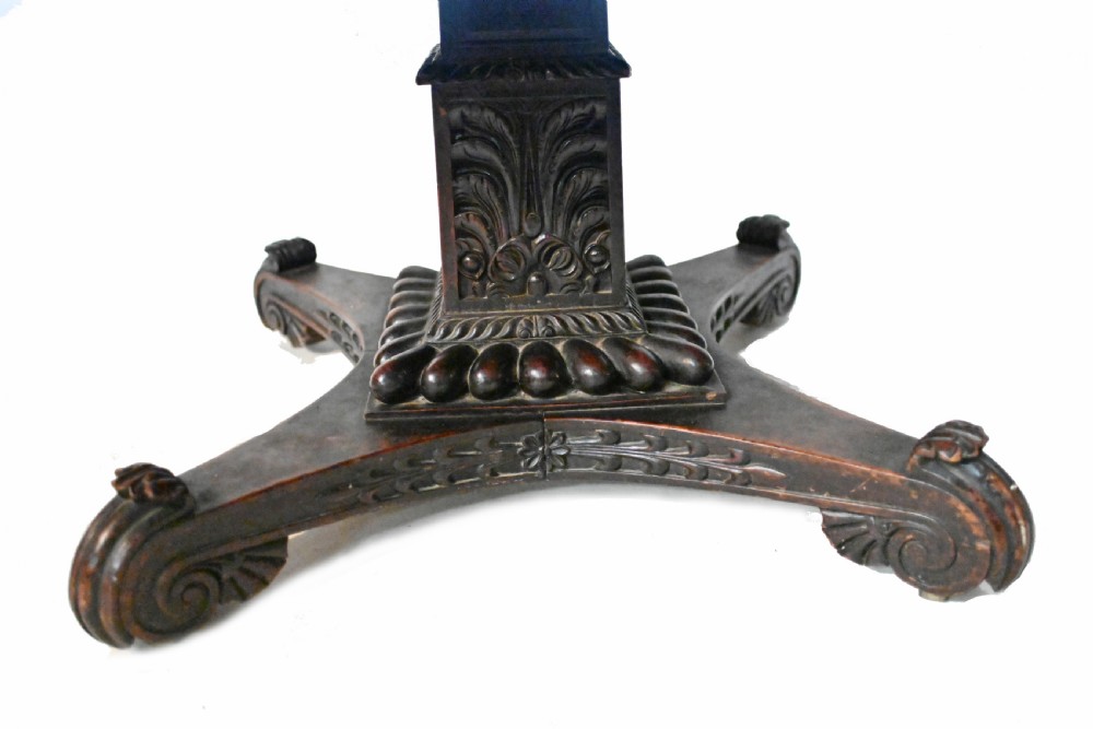 An 1840s Anglo-Indian tilt-top centre table featuring a circular padauk wood top set upon a carved pedestal base. View VIII