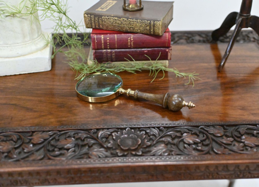 A dark timber rectangular side table featuring a carved foliage border and four legs sculpted as elephant heads with trunks extending to the floor. View IV