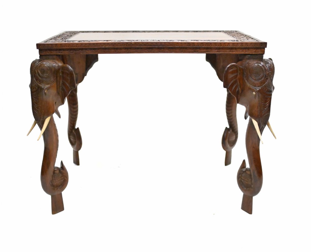 A dark timber rectangular side table featuring a carved foliage border and four legs sculpted as elephant heads with trunks extending to the floor. View VIII