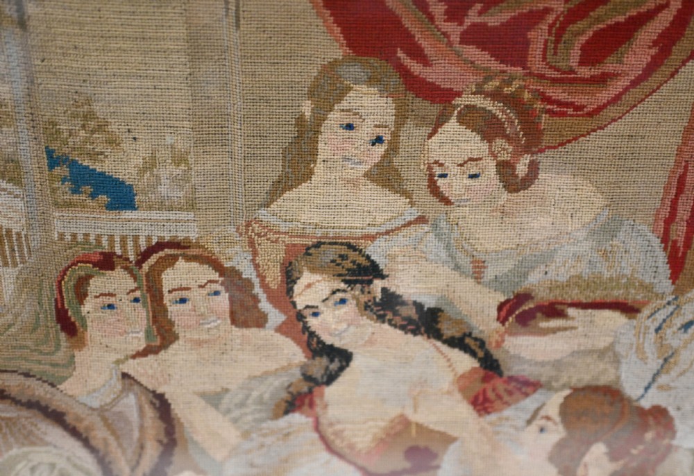 A framed 1865 needlepoint picture depicting a group of courtly maidens in historical dresses, enclosed in an arched gilt black glass mat and polished walnut frame. View II