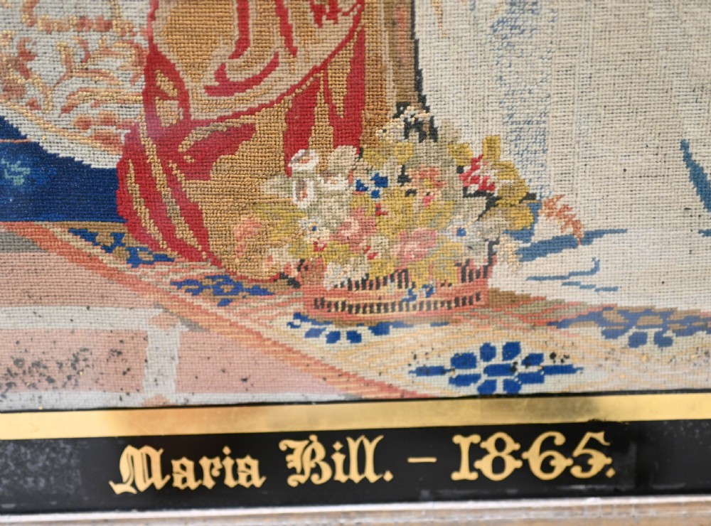 A framed 1865 needlepoint picture depicting a group of courtly maidens in historical dresses, enclosed in an arched gilt black glass mat and polished walnut frame. View VI
