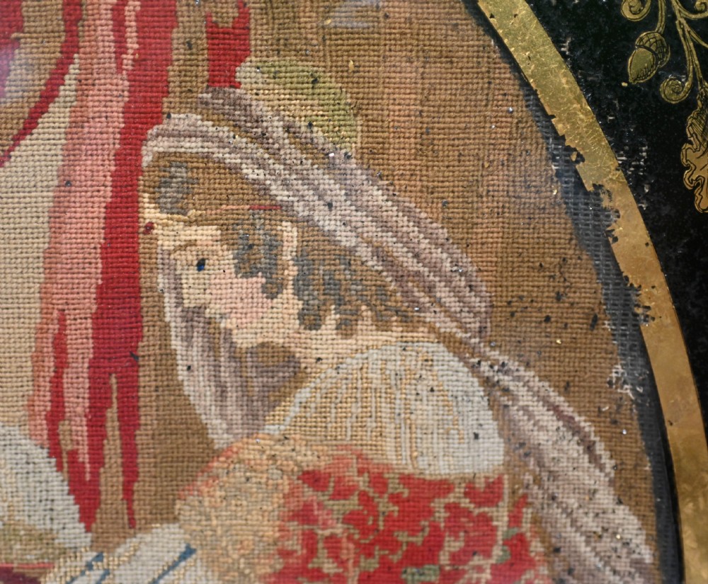 A framed 1865 needlepoint picture depicting a group of courtly maidens in historical dresses, enclosed in an arched gilt black glass mat and polished walnut frame. View IX