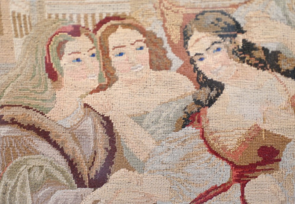 A framed 1865 needlepoint picture depicting a group of courtly maidens in historical dresses, enclosed in an arched gilt black glass mat and polished walnut frame. View X