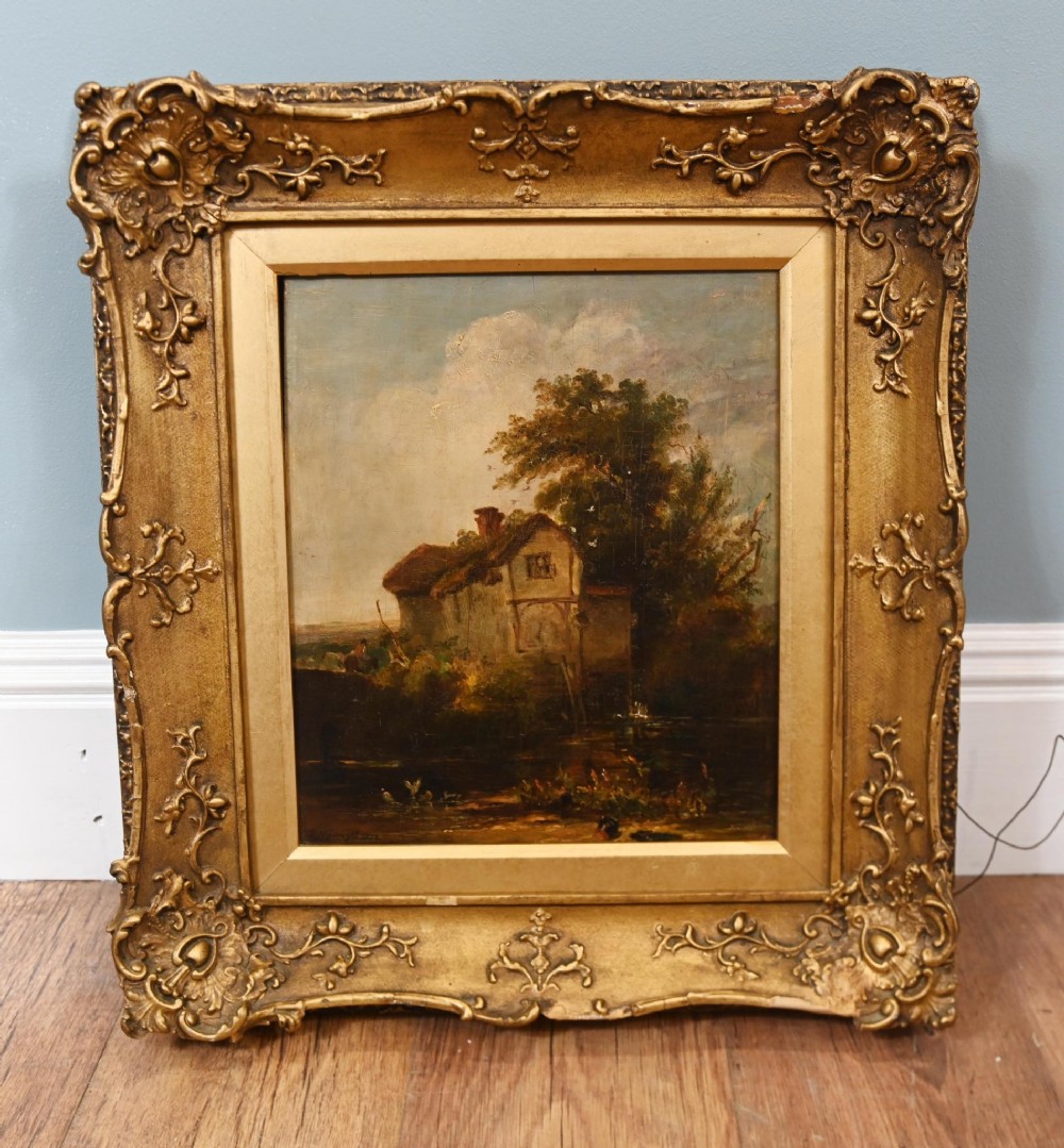 A nineteenth-century Scottish landscape oil painting depicting a rustic cottage beside water, set within an ornate gilded frame.