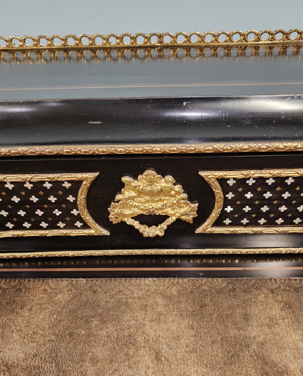 A French Napoleon III ebonised writing desk featuring gilt bronze mounts, brass inlay panels, turned legs, and a raised top superstructure with a brass gallery. View V