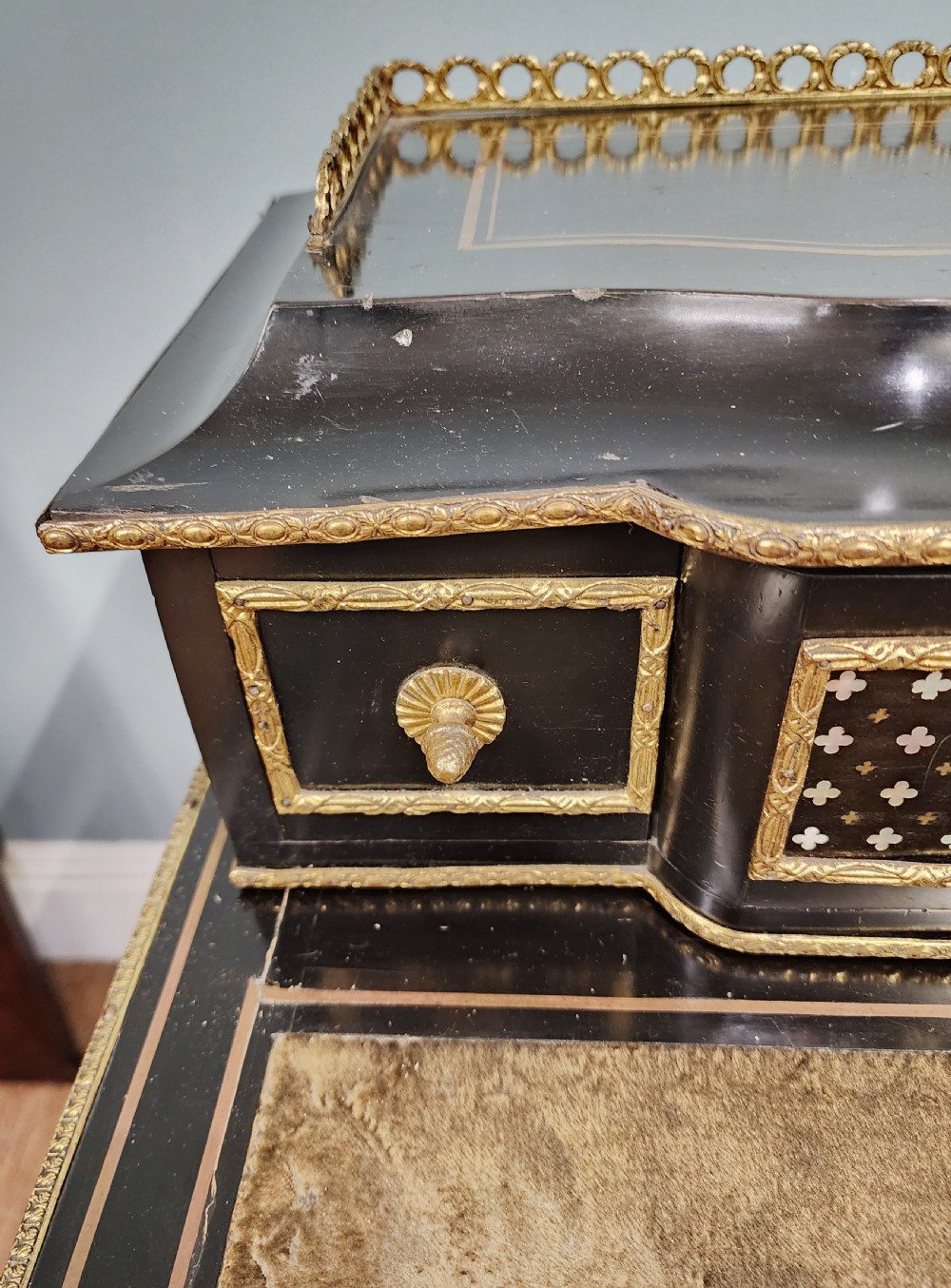 A French Napoleon III ebonised writing desk featuring gilt bronze mounts, brass inlay panels, turned legs, and a raised top superstructure with a brass gallery. View VI
