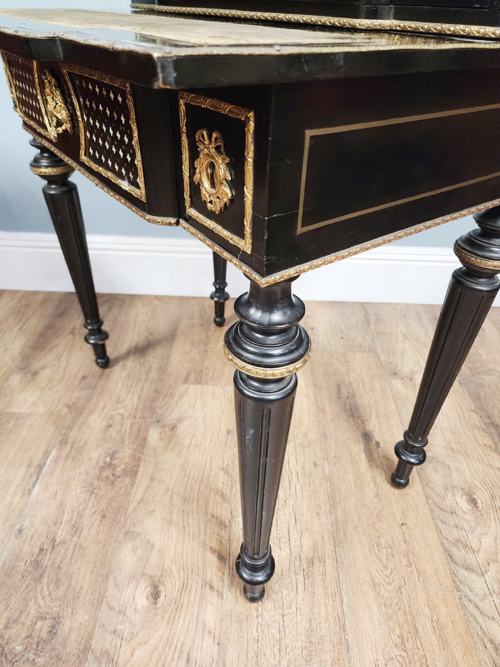 A French Napoleon III ebonised writing desk featuring gilt bronze mounts, brass inlay panels, turned legs, and a raised top superstructure with a brass gallery. View X