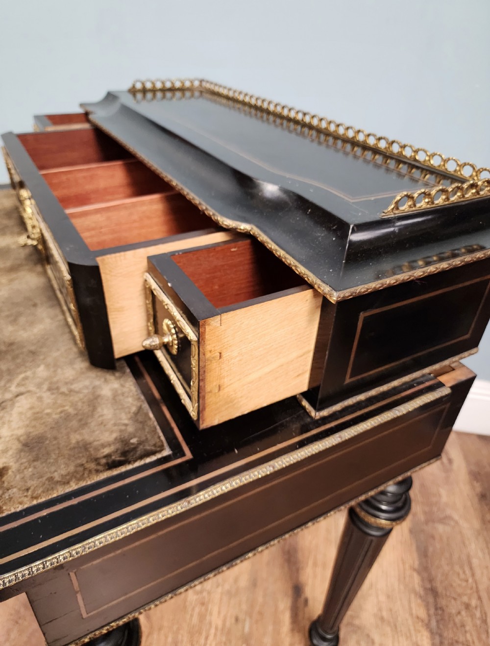 A French Napoleon III ebonised writing desk featuring gilt bronze mounts, brass inlay panels, turned legs, and a raised top superstructure with a brass gallery. View XII