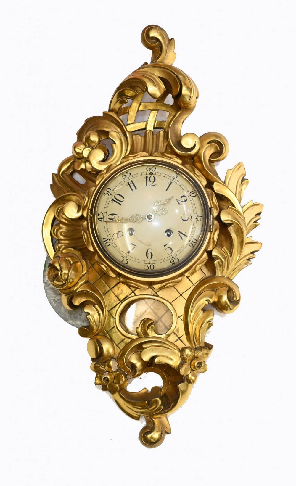 An antique Swedish Rococo style carved giltwood wall clock featuring scrolling acanthus leaf motifs, latticed cresting, floral carvings, and an exposed pendulum window beneath a cream dial.