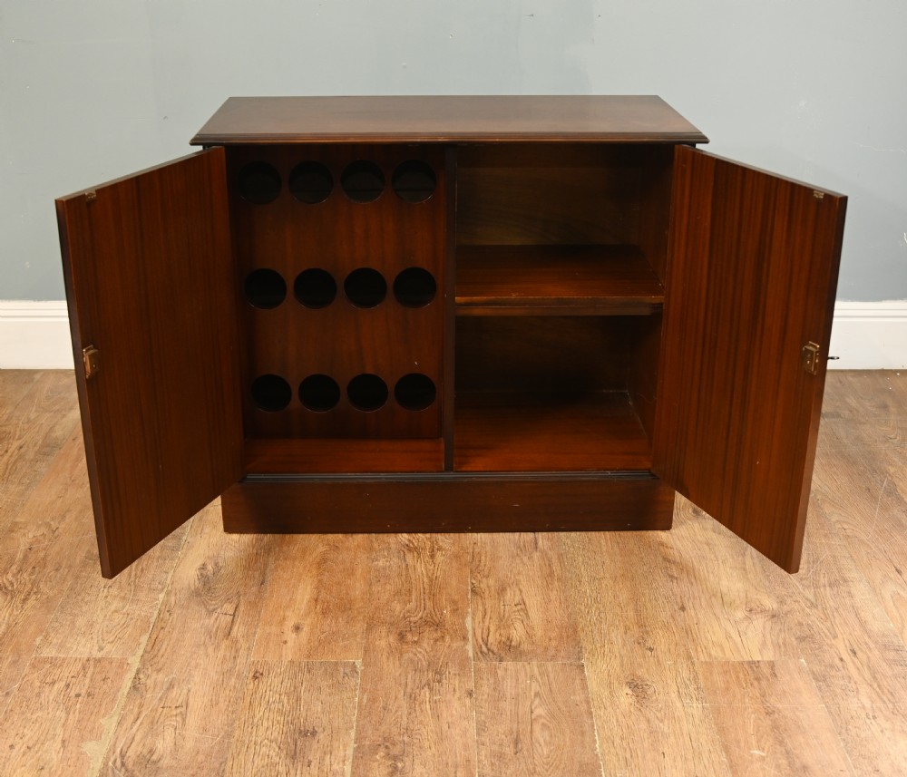 An early Victorian dark mahogany side cabinet featuring two panelled cupboard doors with brass keyhole escutcheons and a plinth base. View III