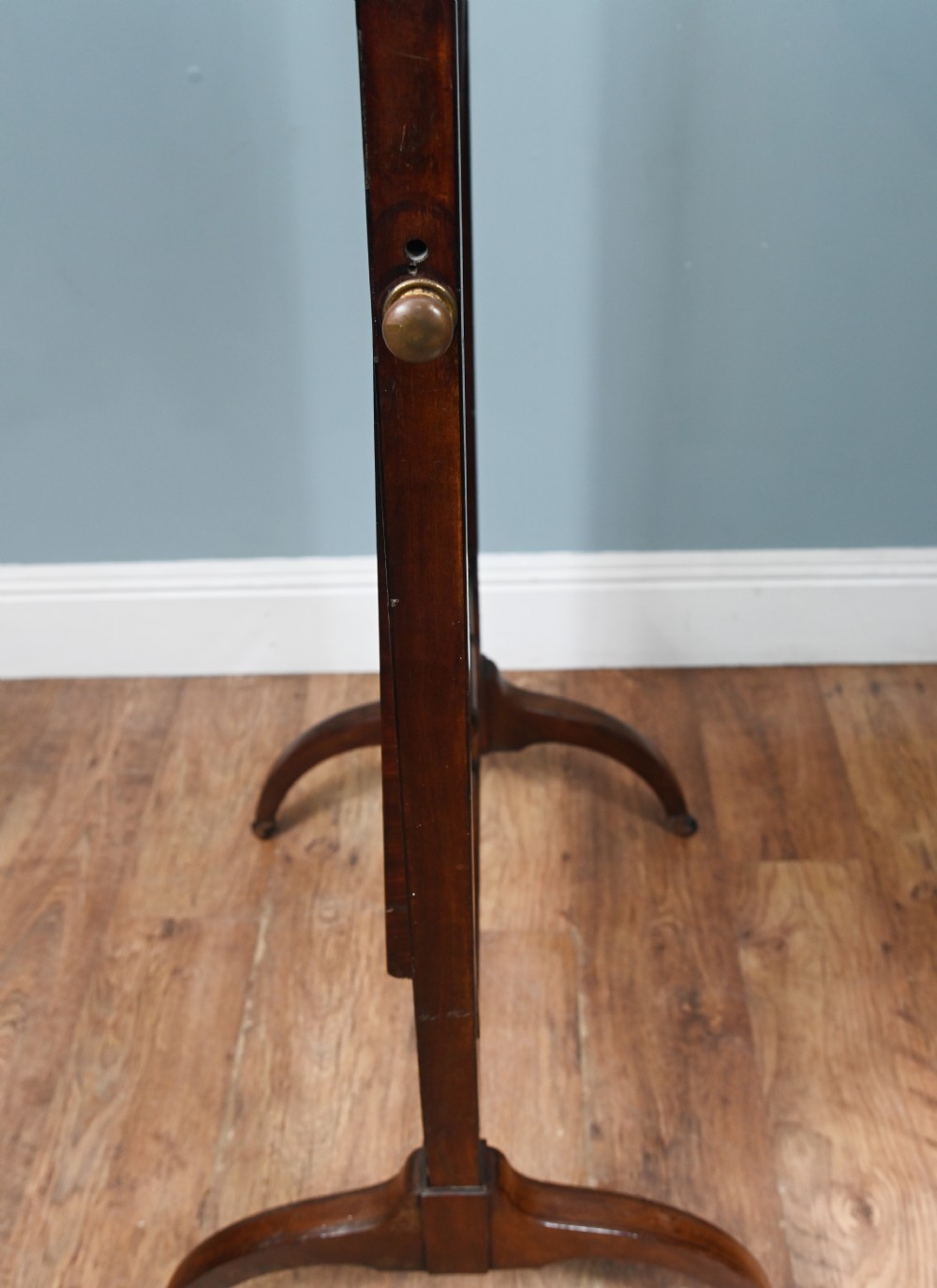 A Regency mahogany cheval mirror featuring an adjustable rectangular mirror plate, turned urn finials, a turned stretcher, and splayed legs on brass castors. View IX