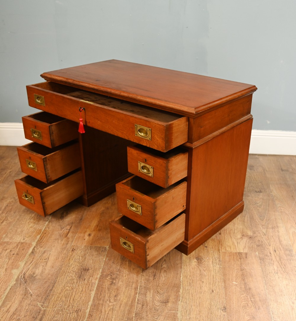 A Victorian mahogany campaign pedestal desk featuring flush brass handles, multiple drawers, and a polished timber surface. View V
