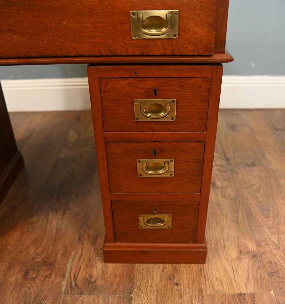 A Victorian mahogany campaign pedestal desk featuring flush brass handles, multiple drawers, and a polished timber surface. View VII