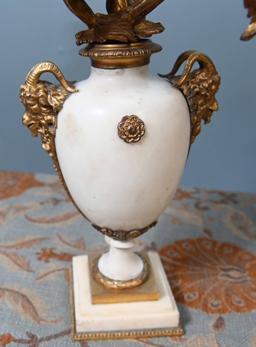 A pair of late 19th-century French Louis XVI Revival gilt bronze and white marble three-arm candelabras featuring urn-shaped bases and floral branch detailing. View III