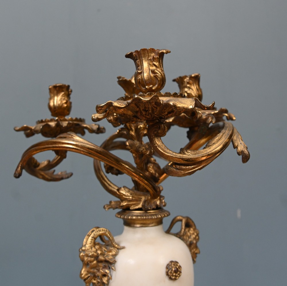 A pair of late 19th-century French Louis XVI Revival gilt bronze and white marble three-arm candelabras featuring urn-shaped bases and floral branch detailing. View VI