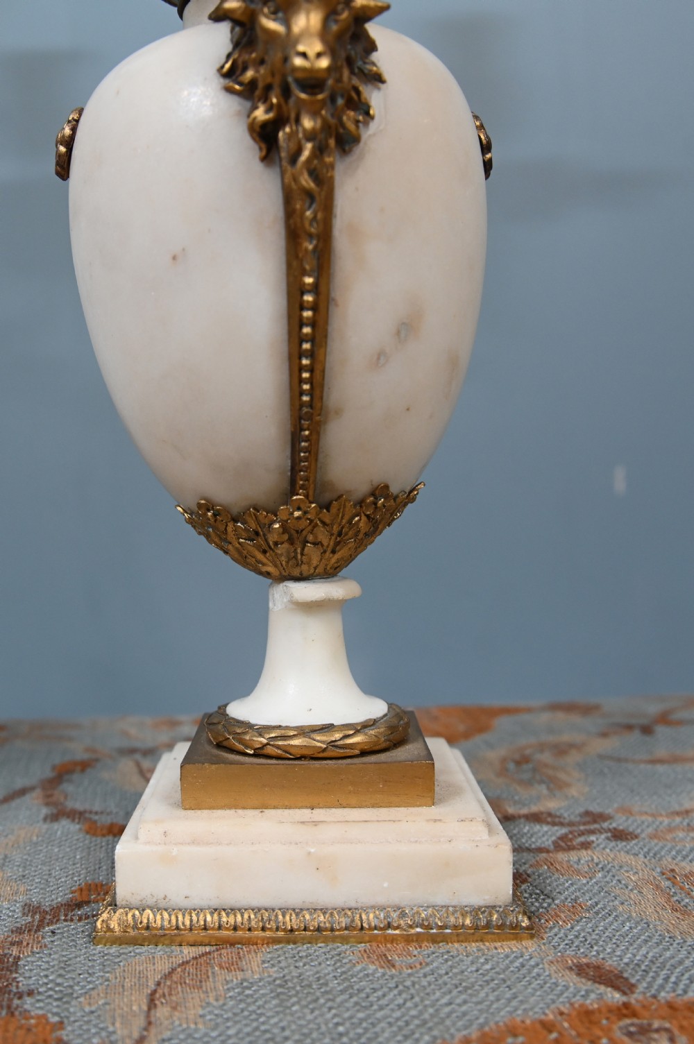A pair of late 19th-century French Louis XVI Revival gilt bronze and white marble three-arm candelabras featuring urn-shaped bases and floral branch detailing. View VIII