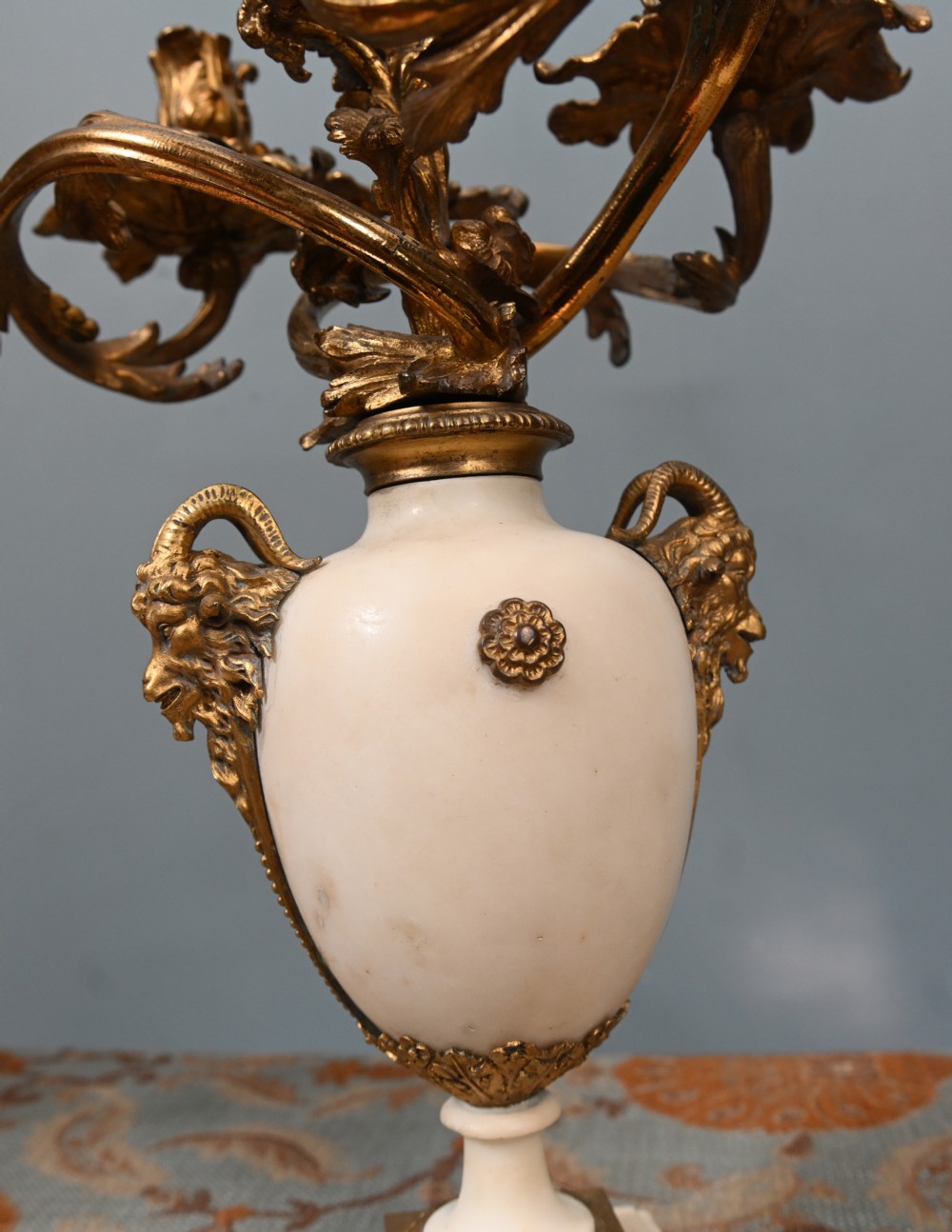 A pair of late 19th-century French Louis XVI Revival gilt bronze and white marble three-arm candelabras featuring urn-shaped bases and floral branch detailing. View IX