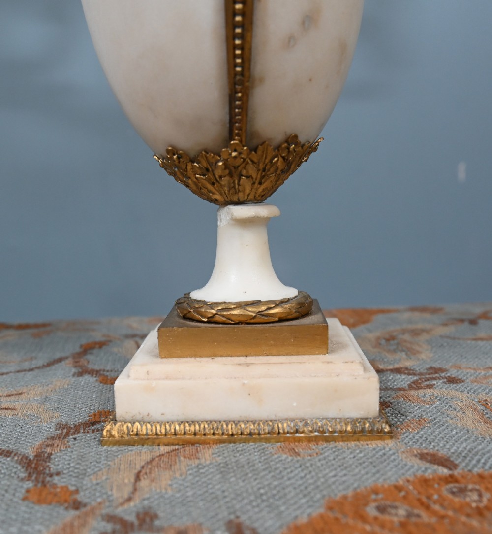 A pair of late 19th-century French Louis XVI Revival gilt bronze and white marble three-arm candelabras featuring urn-shaped bases and floral branch detailing. View XIV