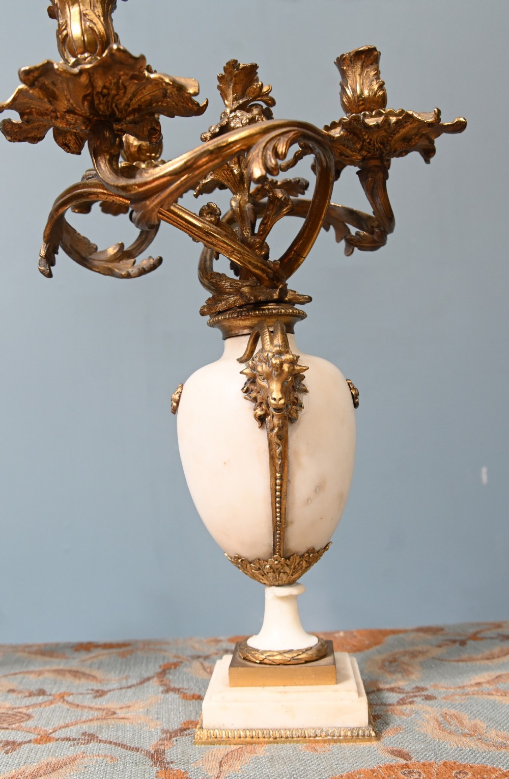 A pair of late 19th-century French Louis XVI Revival gilt bronze and white marble three-arm candelabras featuring urn-shaped bases and floral branch detailing. View XV