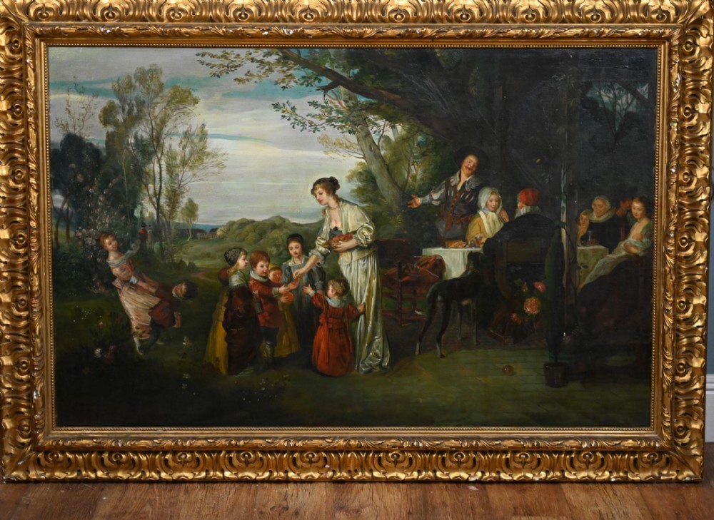 An Edwardian oil painting on canvas depicting a group of figures outdoors in a pastoral setting, mounted within an ornate gilded frame.