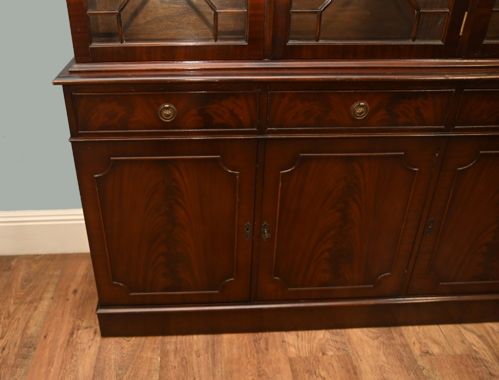 A Georgian Revival mahogany bookcase cabinet featuring a three-door astragal glazed upper section above three drawers and flame mahogany cupboard doors. View III
